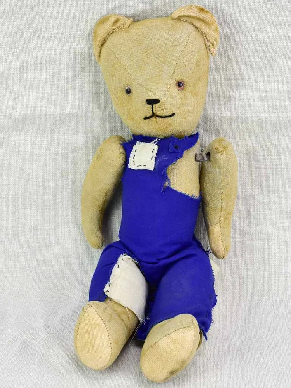 Antique French teddy bear with blue overalls